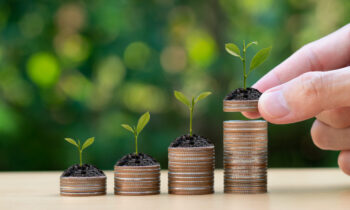 Saving money concept. Hand putting Coins with small plant. Busin