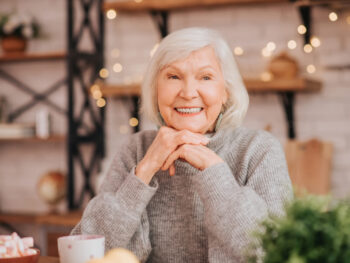 Beautiful elderly woman in grey sweater feeling great