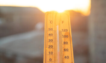 Thermometer on sky background. Sunset. Weather